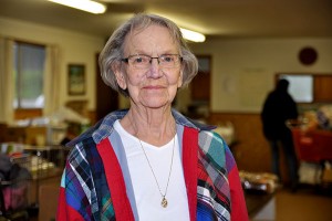 an older woman with glasses looks into the camera