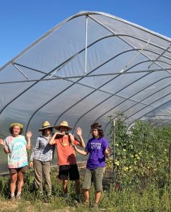 youth farmers pose beneath the new grow tunnel